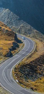 Winding road through brown mountain landscape in mobile wallpaper.