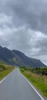 Long road through mountains under cloudy skies.