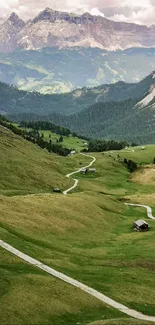 A scenic view of a green mountain valley with a winding path and distant peaks.