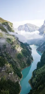 A serene mountain valley with river and clouds in the background.