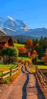 Charming village path with mountains under blue sky.