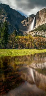 Waterfall against mountains with reflective lake.