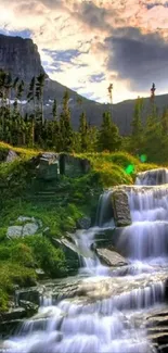 Cascading waterfall with mountain backdrop under a vibrant sunset sky.