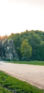 Scenic path with rock formations and greenery under morning light.