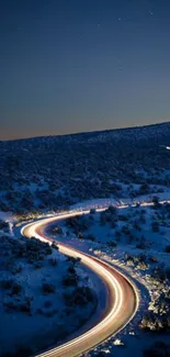 Winding road under starry night in snowy landscape.