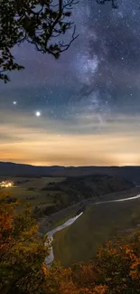 Scenic night sky over a river with autumn trees.