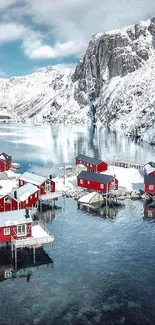 Red cabins by snowy mountain lake in Nordic landscape.