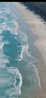 Aerial view of ocean waves crashing on a serene beach.