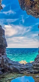 Scenic ocean view through a rocky cave opening on a mobile wallpaper.