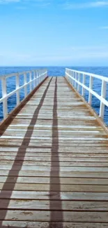 Wooden pier extending into the serene blue ocean under a bright sky.