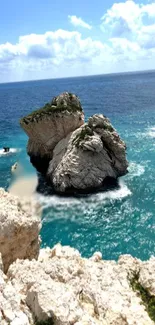 Scenic ocean wallpaper with rocks and blue sea under a bright sky.