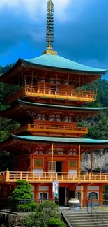 Traditional Japanese pagoda with lush mountain backdrop.