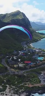 Paragliding over a scenic coastal mountain and ocean view.