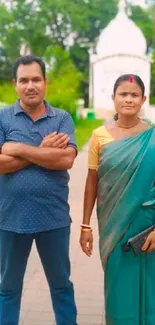 Couple walking on scenic path with greenery and temple.