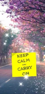 Serene road with pink blossom trees and a motivational sign.