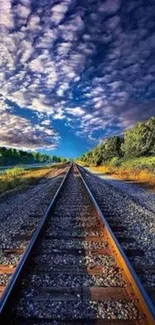 Railway tracks leading into vibrant horizon with lush greenery and dramatic sky.