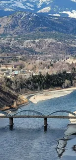 Scenic view of river and mountains with a bridge.