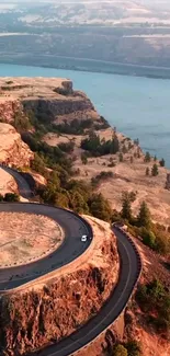 Winding road through a scenic canyon by a river.