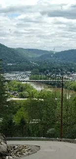 Winding road through lush green valley and river view.