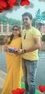 Couple by riverfront with heart decorations.