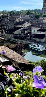 Scenic view of a riverside town with flowers and historic buildings.