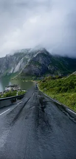 Winding road through a mountain landscape with misty skies.