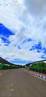 Vibrant road leading under blue sky with clouds.