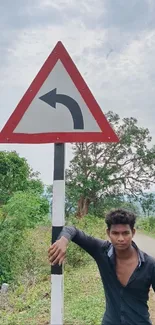 Person leaning on road sign with scenic background.