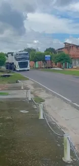 White truck on a scenic village road with greenery and sky.