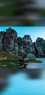 Breathtaking dusk view of rock formations with vibrant teal sky.