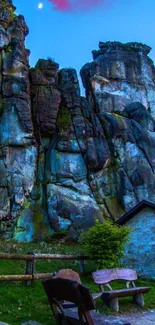 Majestic rock formations under twilight blue sky, featuring lush greenery.