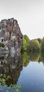 Mobile wallpaper of rocks reflecting on a tranquil lake.