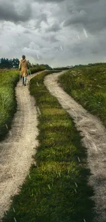 A scenic rural pathway through lush green fields under a dramatic cloudy sky.