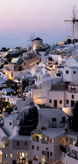 Enchanting Santorini evening view with white houses and windmills.