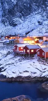 Snowy mountain village by frozen sea at dusk.