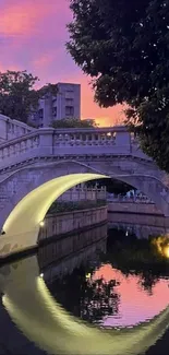 Majestic bridge at sunset with reflective waters and a colorful sky.