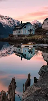 Sunset reflects on a tranquil lake with mountains and houses.