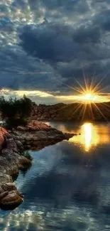 Serene sunset over calm water with dramatic clouds and reflections.