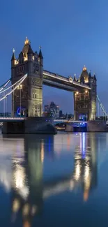 London's Tower Bridge illuminated at dusk with reflections on the Thames.