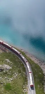 A train travels along a tranquil aquamarine lake beside lush greenery.