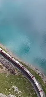 Aerial view of a train by a stunning blue lake, perfect for mobile wallpaper.