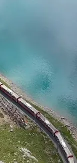 Train travels by a serene, turquoise lake.