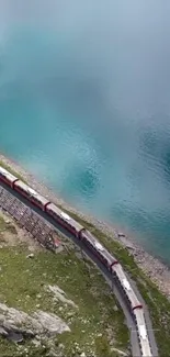 A scenic train travels along a turquoise mountain lake, offering breathtaking views.