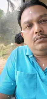 Man in blue shirt enjoying train view.