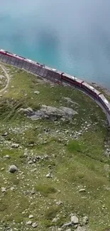 Scenic train ride beside a turquoise lake in nature.