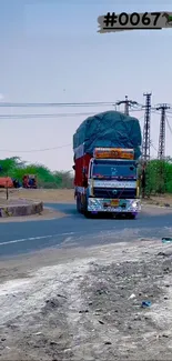 Colorful truck on a rural road with clear sky and greenery.