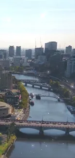 Scenic cityscape with a river and bridge under a clear blue sky.