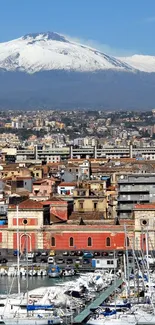 Catania harbor with Mount Etna and boats under a blue sky.