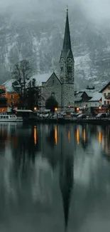 Serene village with church reflected in misty waters at dawn.