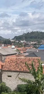 Scenic view of village rooftops and lush greenery.